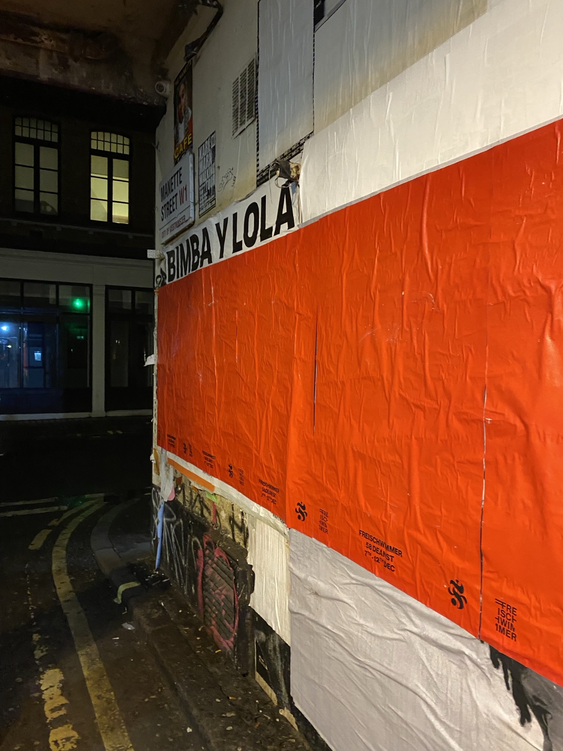 Orange Freischwimmer posters on a Soho street wall