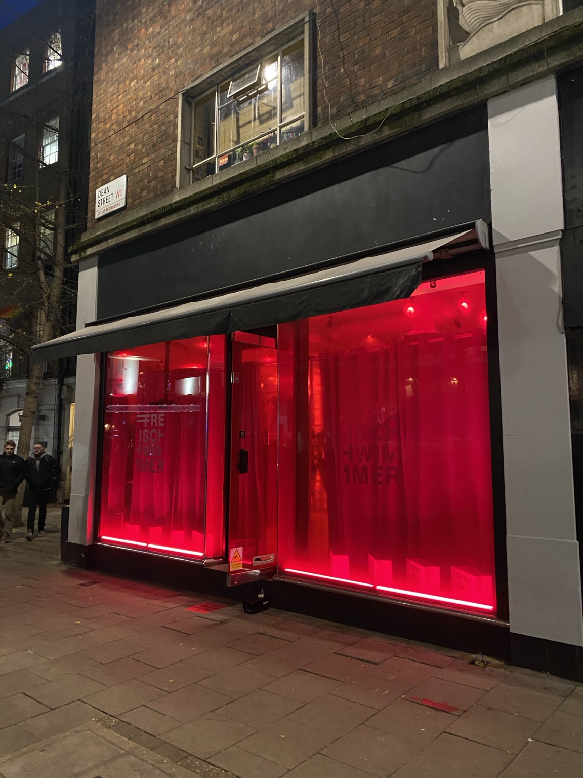 Freischwimmer Studios pop-up on Dean Street, glowing red at night